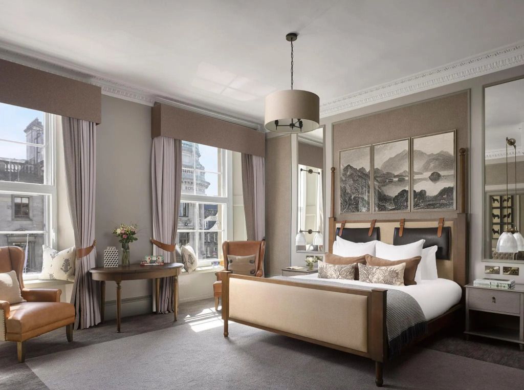 Elegantes Schlafzimmer in einer Suite mit Stadtblick, stilvollen Möbeln und großem Fenster.