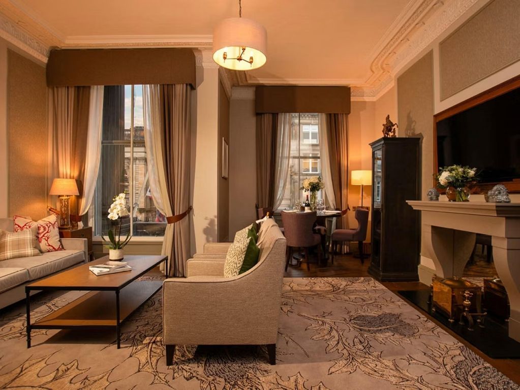 Wohnbereich der Ferrier Suite mit großer Fensterfront und stilvollen Möbeln.