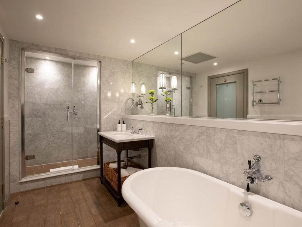 Modernes Badezimmer in der Ferrier Suite mit freistehender Badewanne und Glasdusche.