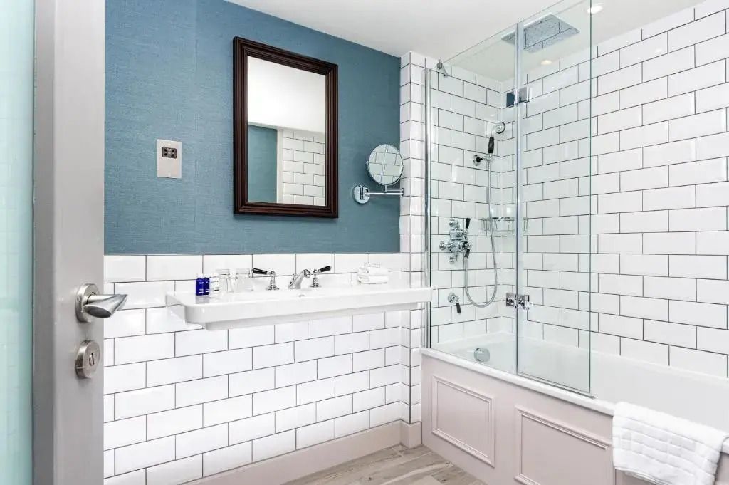 Modernes Badezimmer mit weiß gekachelter Wand und Badewanne-Duschkombination