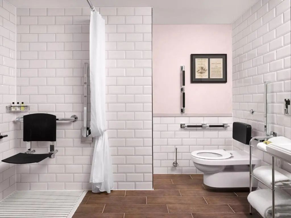 Modernes Badezimmer mit weißen Fliesen und Holzboden.