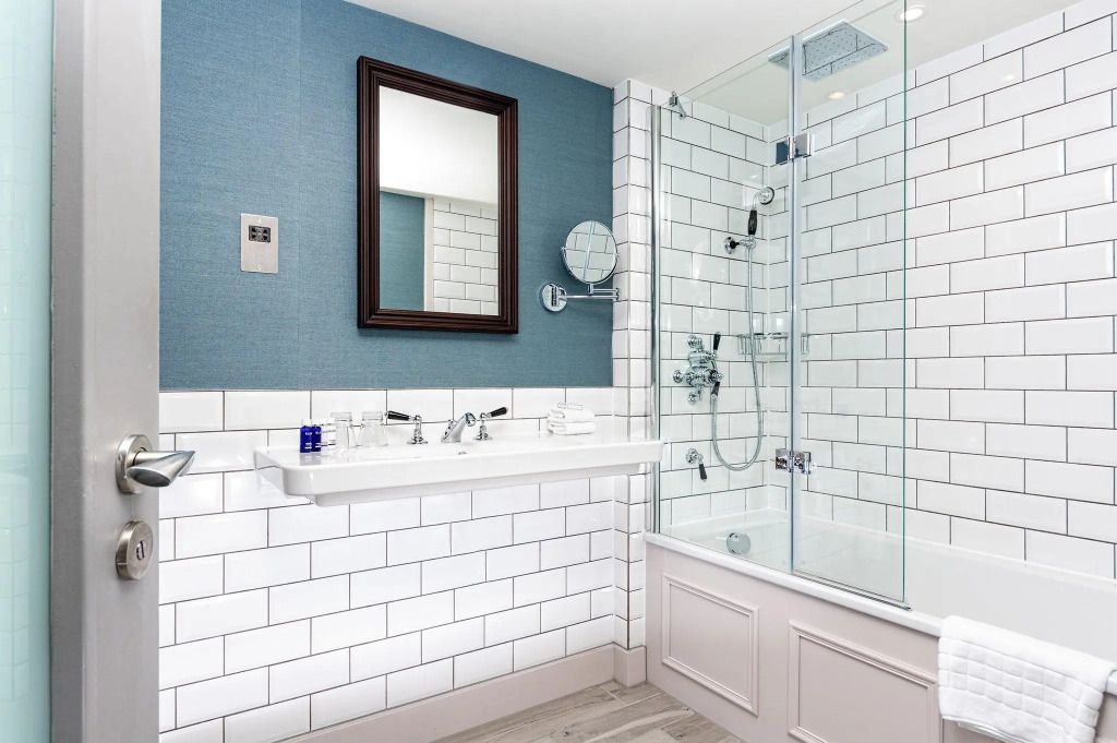 Modernes Badezimmer mit Glasdusche und stilvollen weißen Fliesen