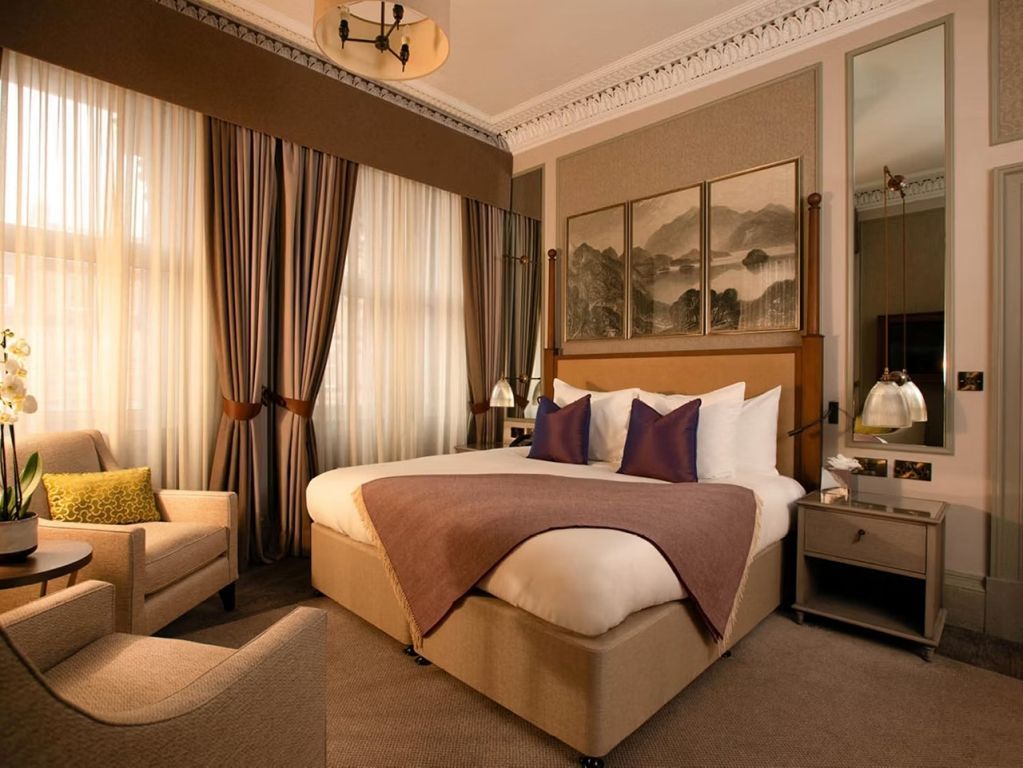 Luxuriöses Schlafzimmer mit großem Bett und opulenter Dekoration in warmen Farben.