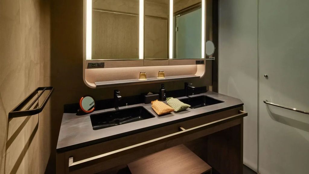 Modernes Badezimmer mit Doppelwaschbecken und beleuchtetem Spiegel