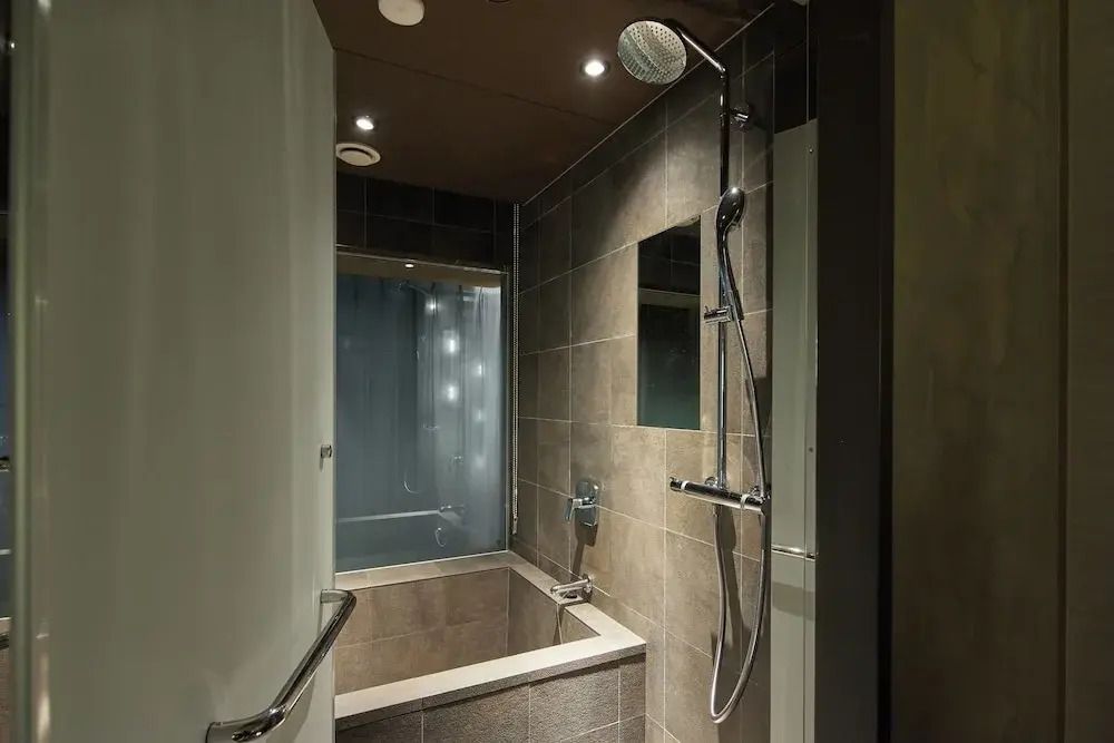 Badezimmer mit eleganter Dusche und modernen Fliesen.