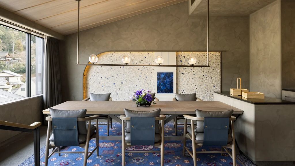 Stilvoller Essbereich mit großem Tisch, Designerleuchten und eleganter Dekoration.