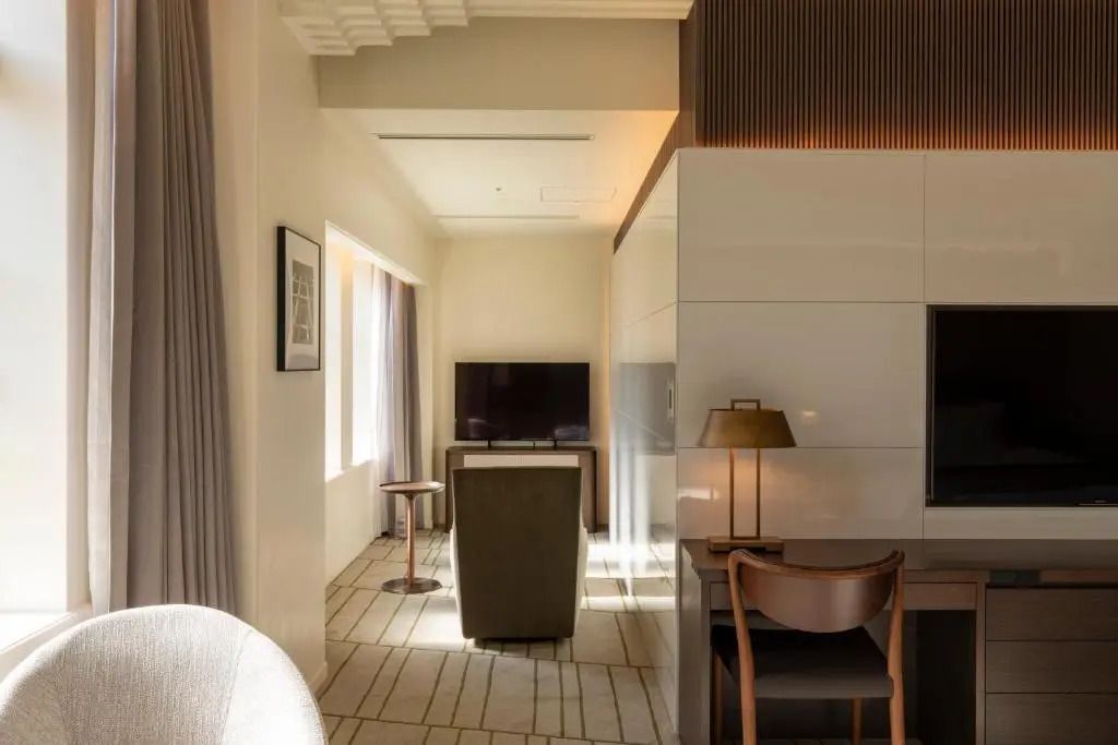 Wohnbereich mit Fernseher und stilvollem Design in einem Hotelzimmer