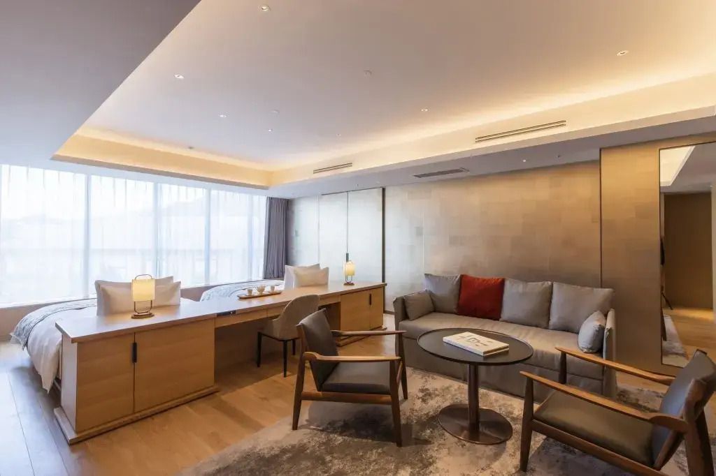 Geräumiger Wohnbereich der modernen Junior-Suite mit Sofagruppe und großem Fenster.