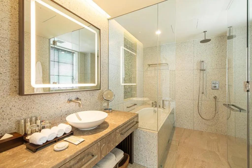 Luxuriöses Badezimmer mit großer Badewanne, Spiegel und moderner Beleuchtung