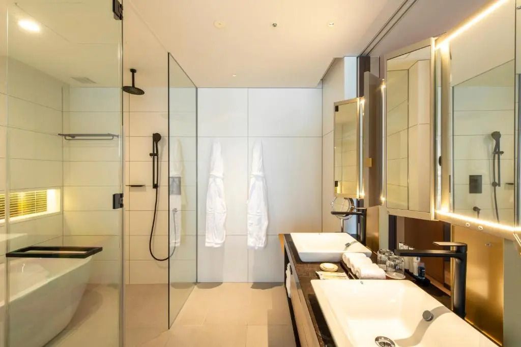 Modernes Badezimmer mit Glasdusche und doppeltem Waschbecken