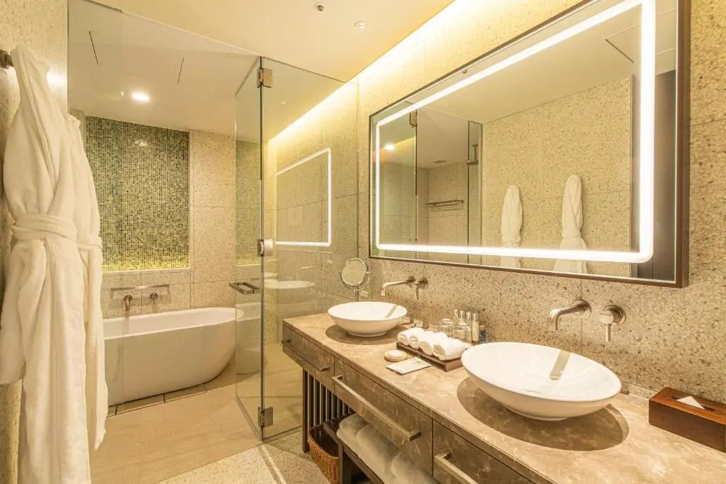 Elegantes Badezimmer mit Doppelwaschbecken und beleuchtetem Spiegel.