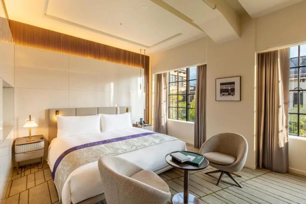 Modernes Doppelzimmer mit großem Fenster und eleganter Einrichtung