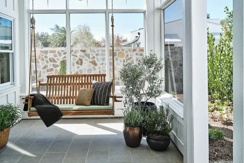 Heller Wintergarten mit Hängesitz und üppigen Pflanzen als entspannender Rückzugsort