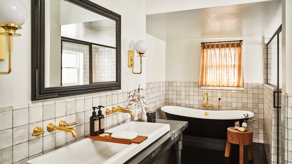 Edles Badezimmer mit freistehender Badewanne und goldenen Armaturen