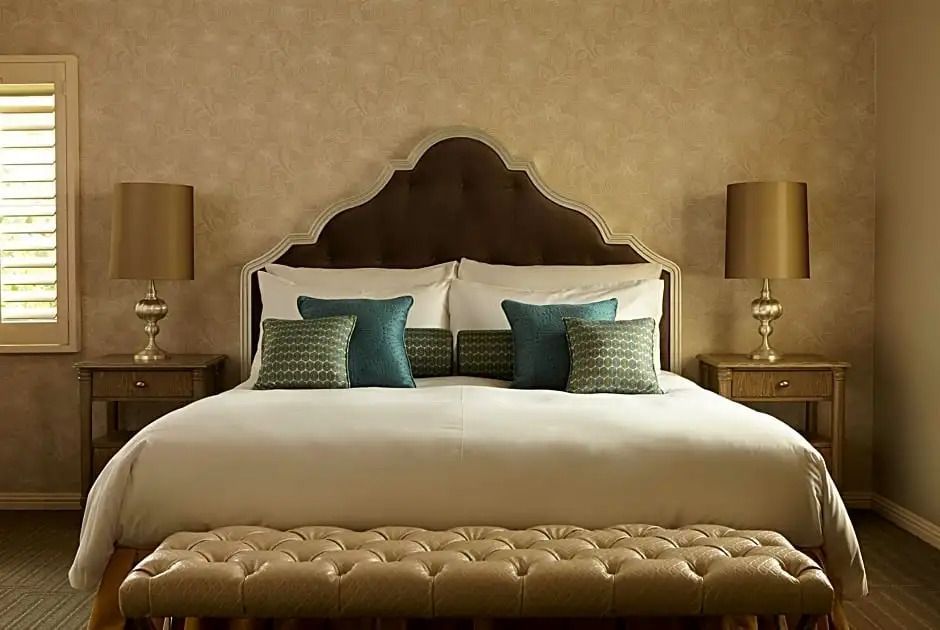 Luxuriöses Bett mit stilvollen Kissen und Nachttischen im Deluxe Doppel Zimmer.