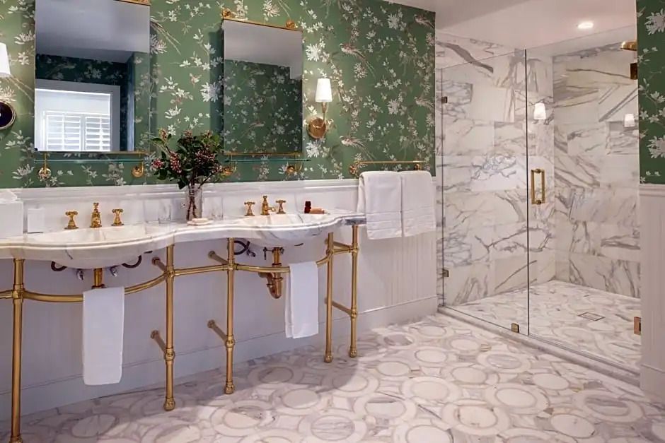 Luxuriöses Badezimmer mit eleganten Marmorakzenten und grüner Tapete