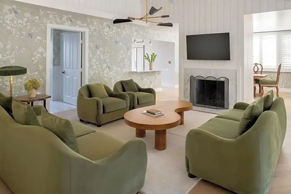 Wohnzimmer mit stilvollen Sesseln, Kamin und TV