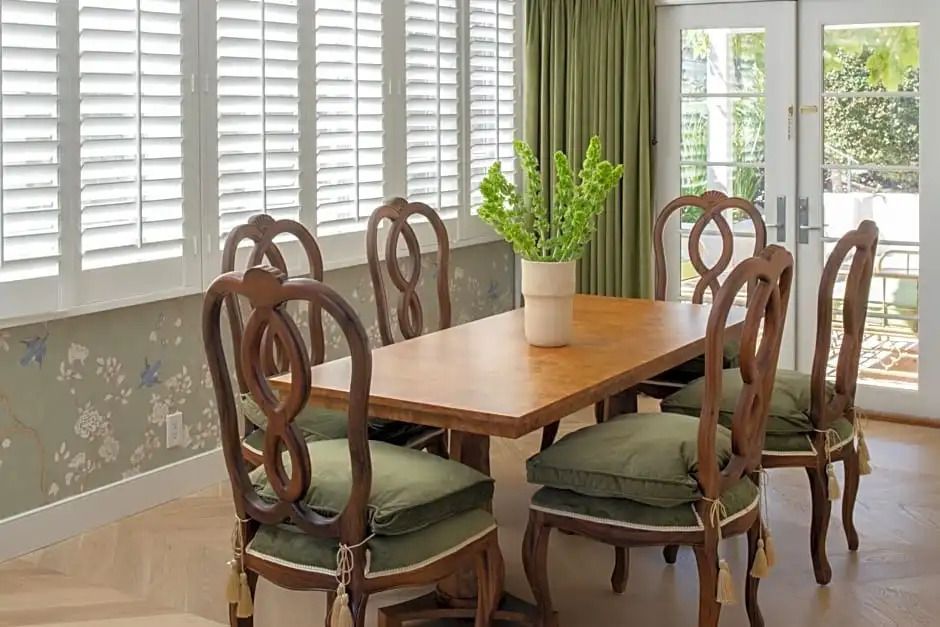Essbereich mit Holztisch und eleganten Stühlen vor großen Fenstern