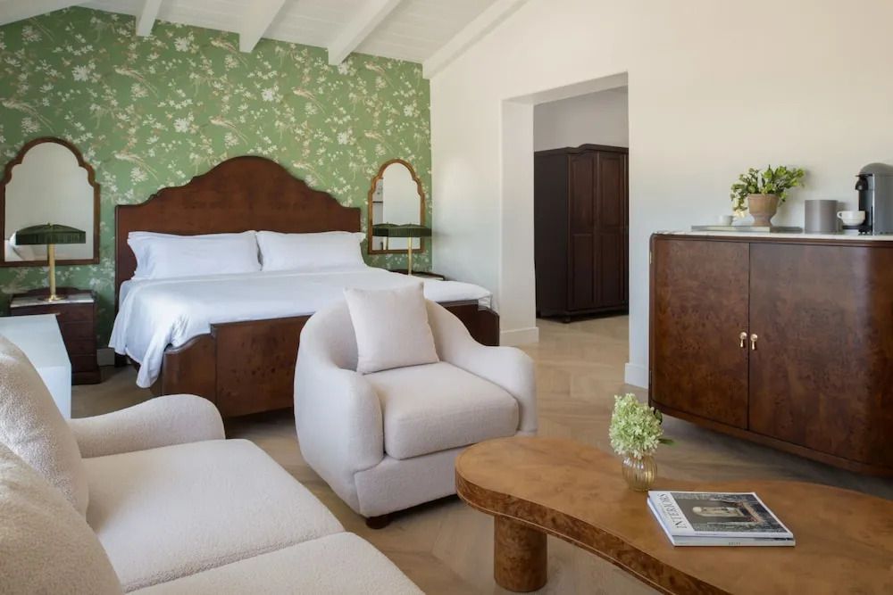 Premier Doppelzimmer mit Bett, Sessel und Holzmöbeln im eleganten Stil.