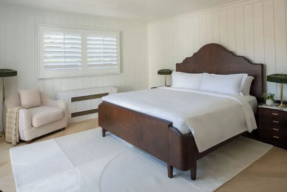 Helles Schlafzimmer mit großen Holzbett und klassischer Einrichtung