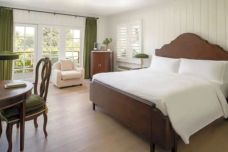 Helles Schlafzimmer mit Doppelbett und gemütlichem Sessel im Standard Bungalow