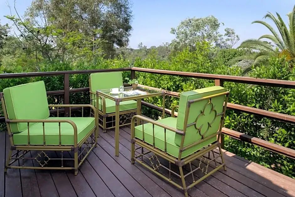 Private Terrasse mit grünen Stühlen und Blick auf die Natur