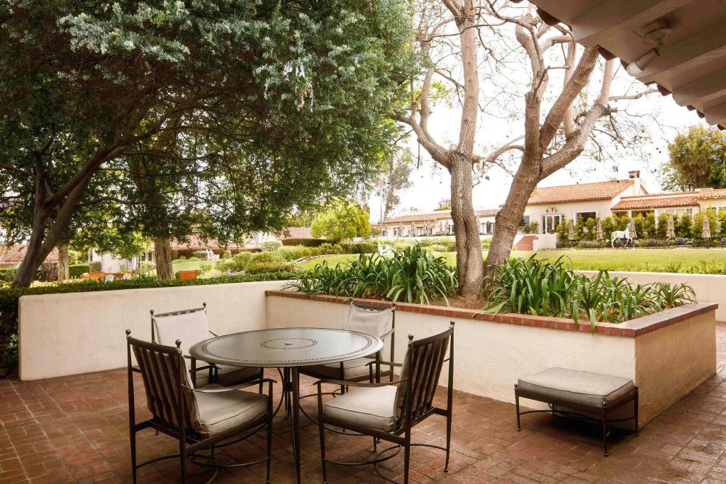 Gartenblick von einer Terrasse mit Sitzgelegenheiten im Hotel