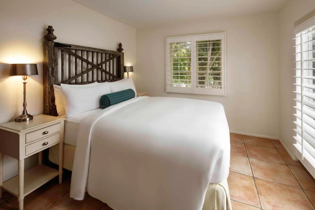 Geräumige Suite mit elegantem Doppelbett und Blick auf den Innenhof durch ein Fenster