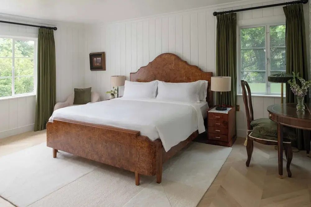 Schlafzimmer mit großem Bett, eleganter Holzverkleidung und gemütlicher Atmosphäre