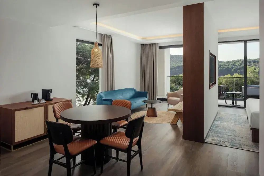 Wohnbereich einer modernen Suite mit Esstisch und Blick ins Freie