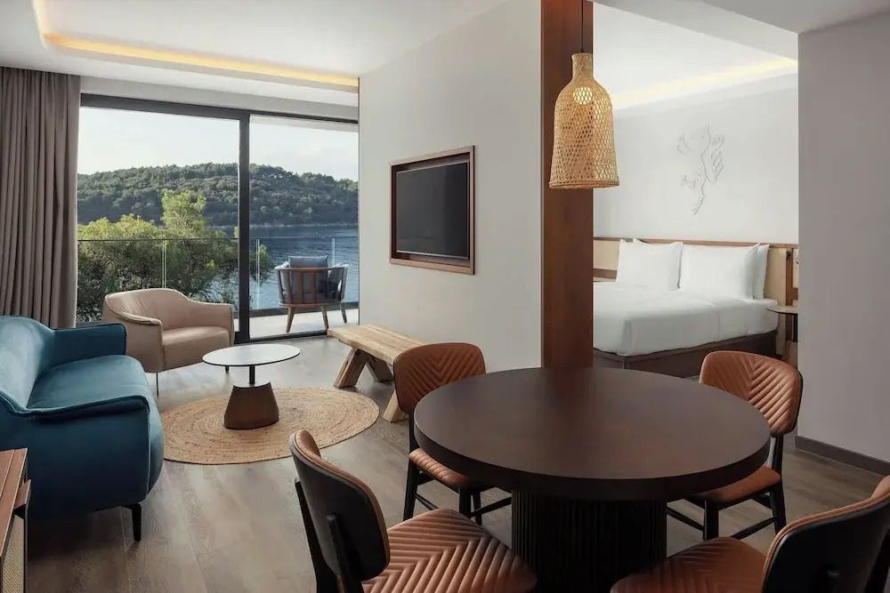 Suite mit Doppelbett, Esstisch und Aussicht auf den Wald