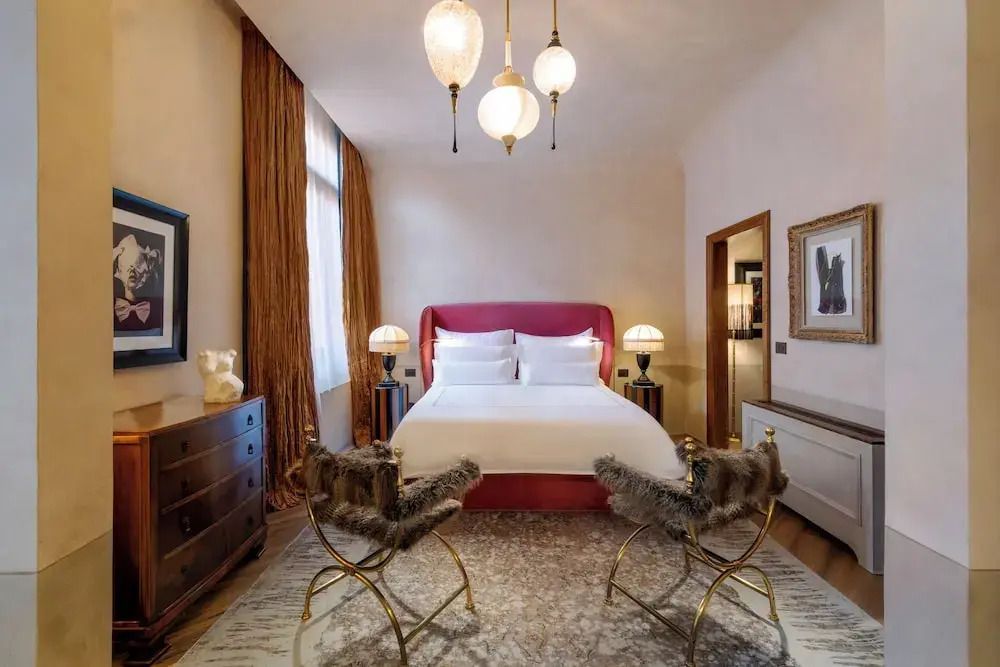 Luxuriöses Doppelzimmer mit Designer-Stühlen und heller Beleuchtung.