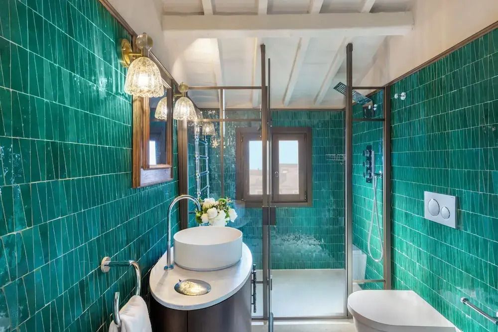 Modernes Badezimmer mit grünen Fliesen und eleganter Beleuchtung