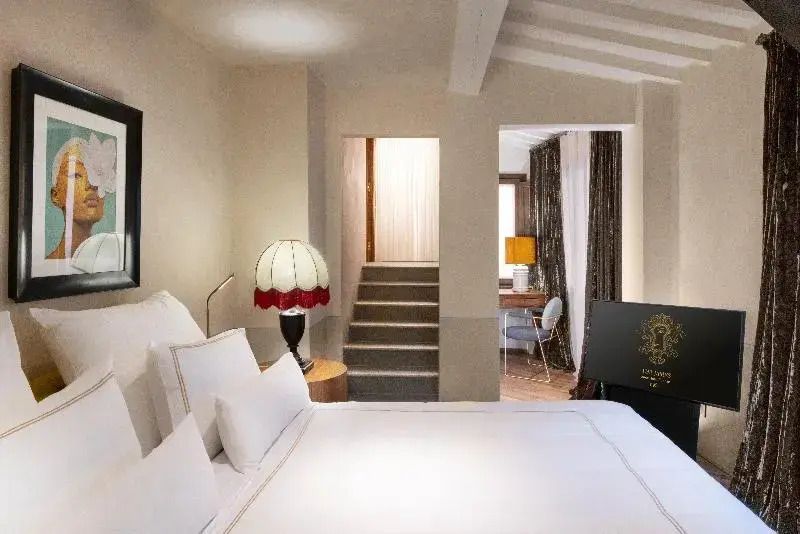Stilvolles Schlafzimmer mit bequemer Bettwäsche und Zugang zu angrenzendem Arbeitsbereich.