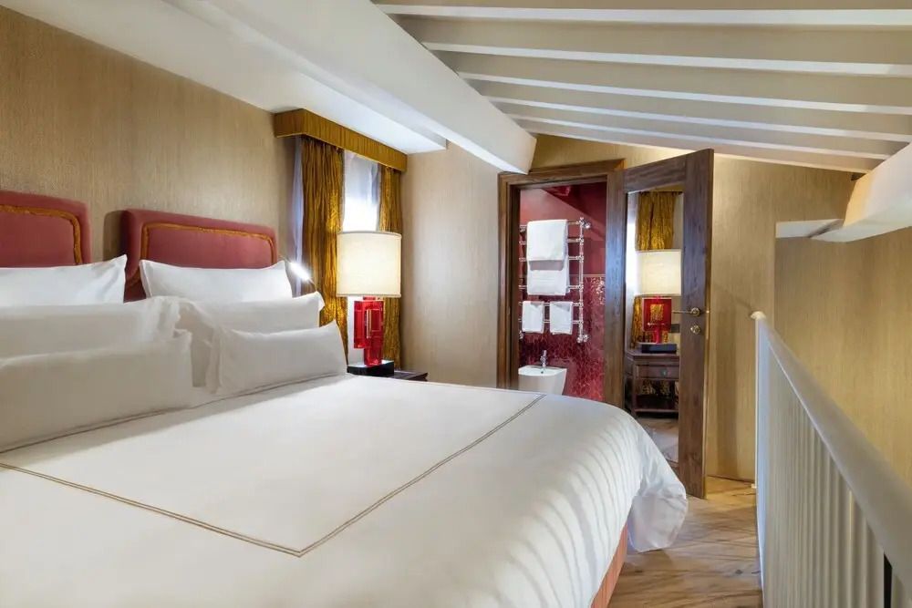 Luxuriöse Suite mit Holzbalkendecke und moderner Beleuchtung.