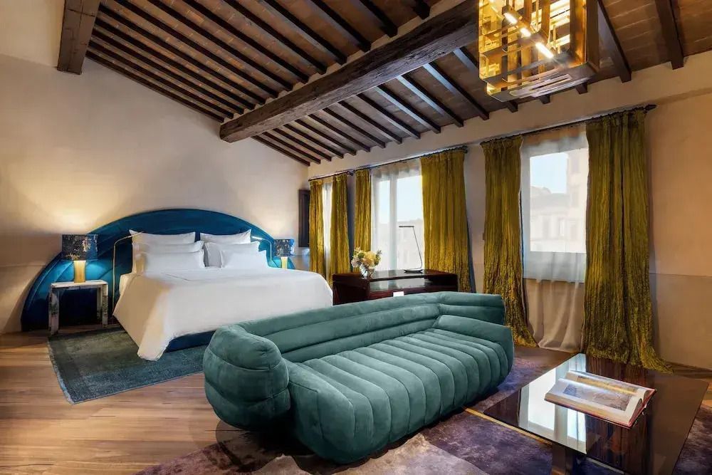 Suite mit rustikalem Holzbalkendach und grüner Designer-Couch.