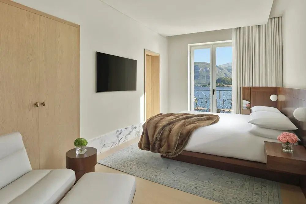 Zimmer mit Fernseher, großem Fenster und Aussicht auf den Comer See