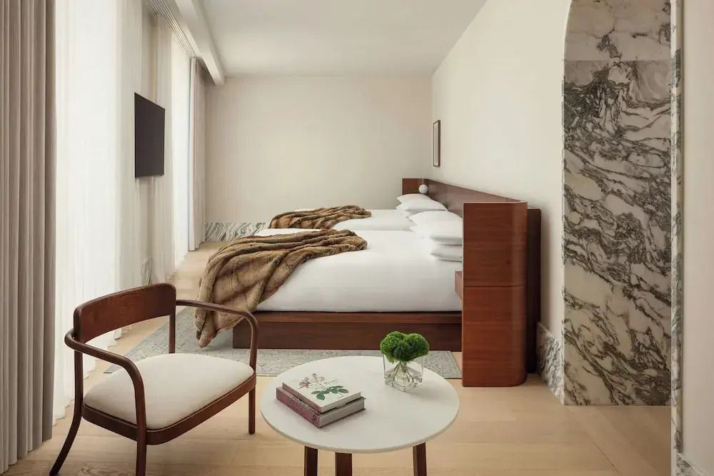 Zwei großzügige Betten in einem modernen Hotelzimmer mit Deko-Elementen.
