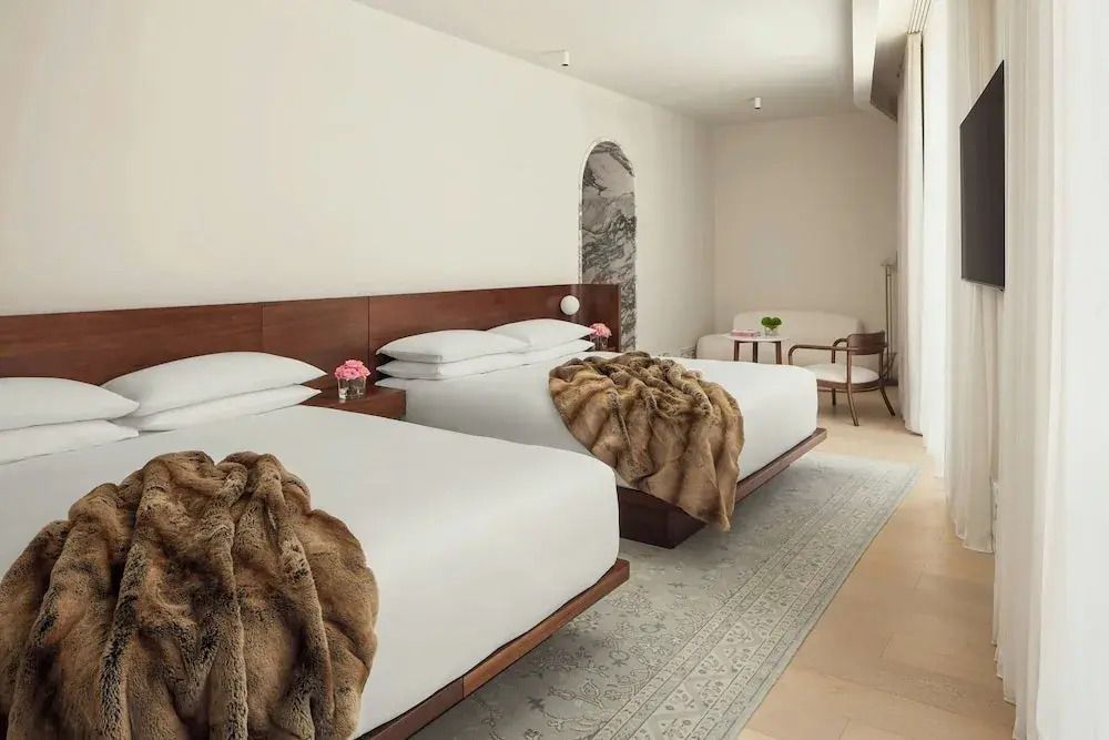 Gemütliches Hotelzimmer mit zwei großen Betten und zeitlosem Design.