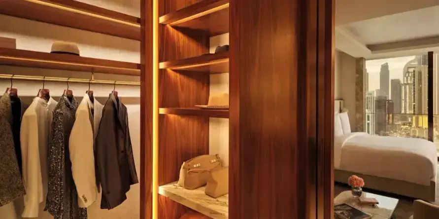 Begehbarer Kleiderschrank mit Holzregalen und Beleuchtung