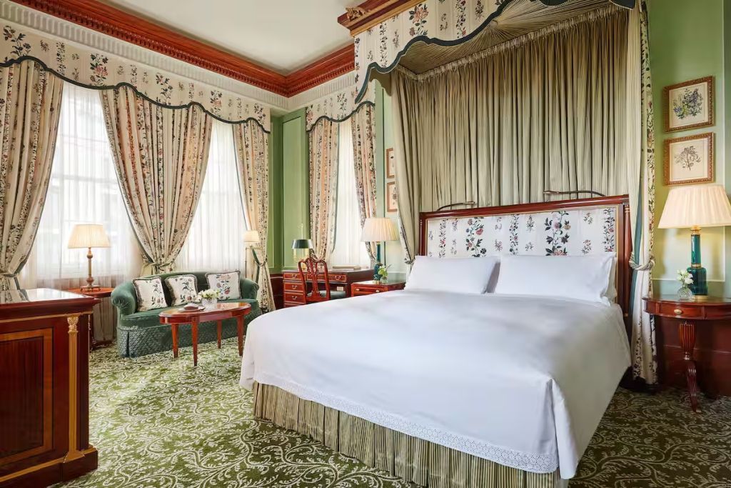 Elegante Junior-Suite mit opulenten Vorhängen und einem komfortablen Doppelbett.