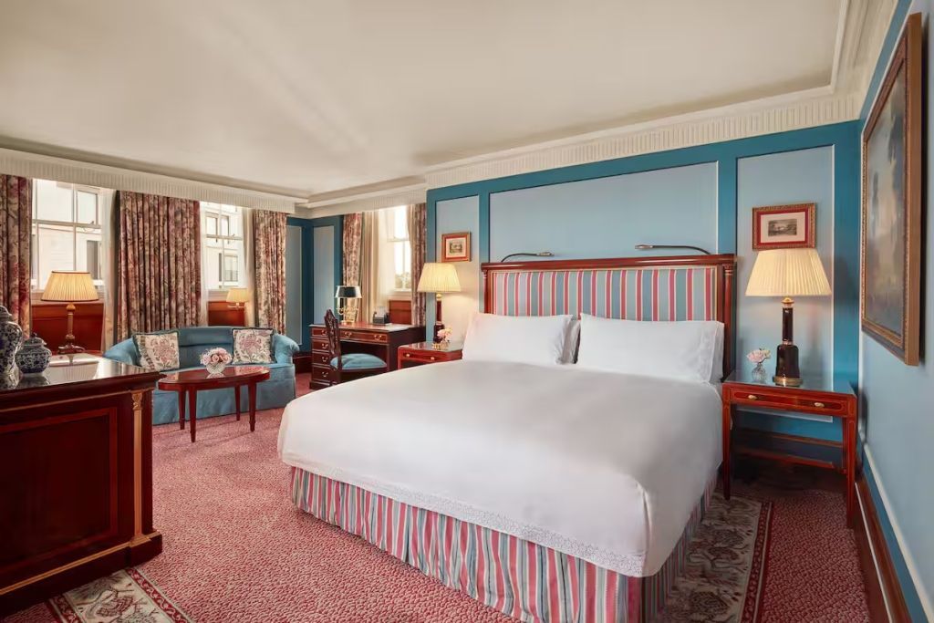 Geräumige Suite mit Doppelbett und stilvoller Einrichtung in Blau und Rot.
