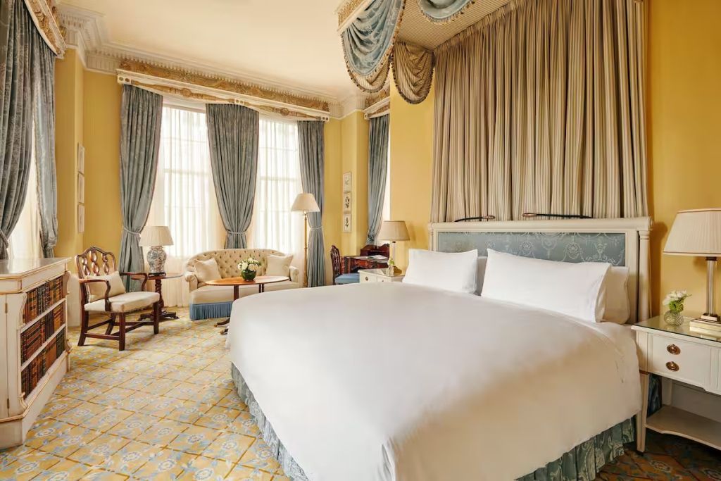 Helle Junior-Suite mit großen Fenstern und luxuriösen Stoffen.