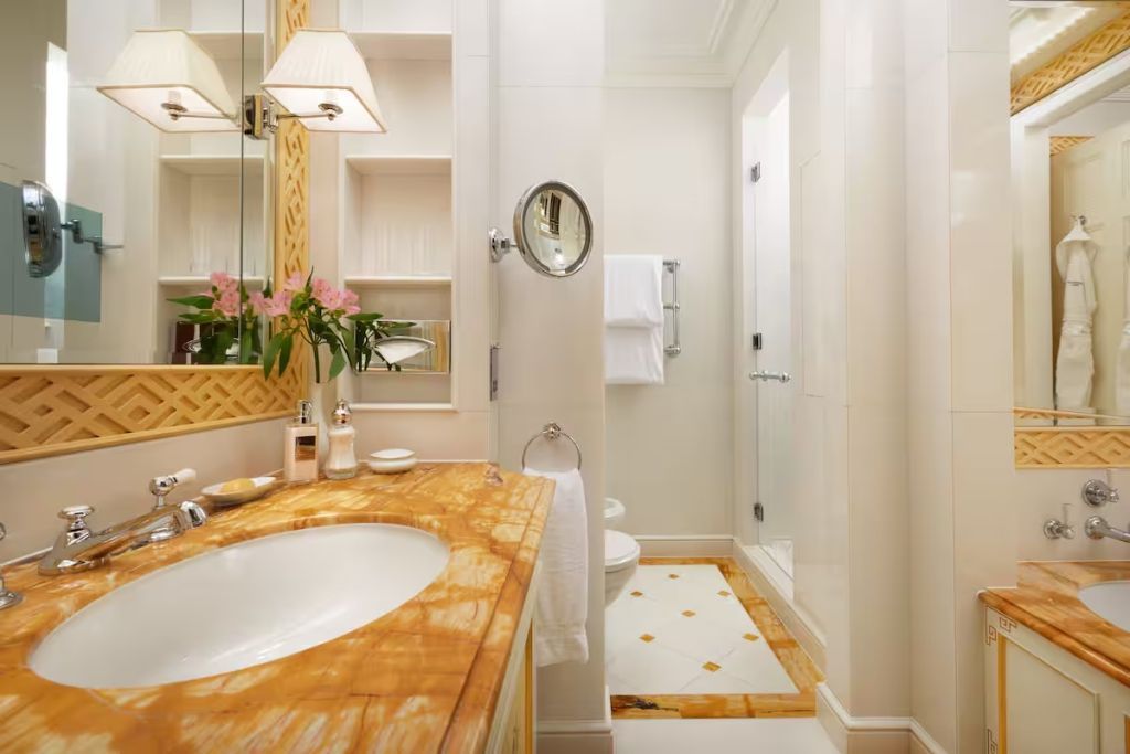 Luxuriöses Badezimmer mit marmoriertem Waschtisch und geräumiger Dusche.