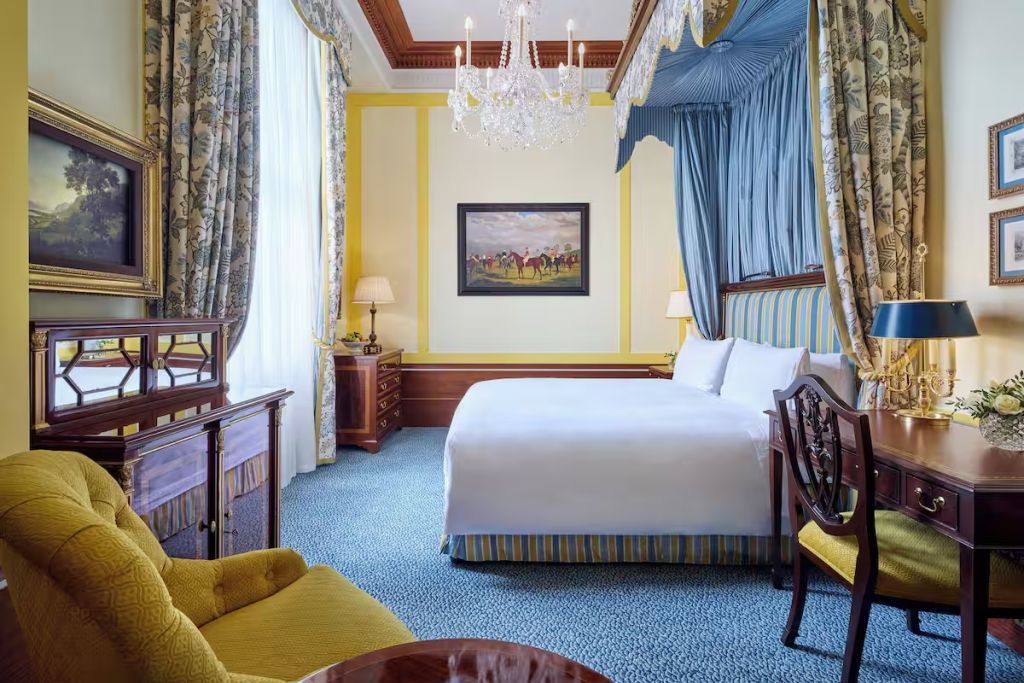 Luxuriöses Zimmer mit blauen Vorhängen und prachtvollem Kronleuchter über dem Bett.