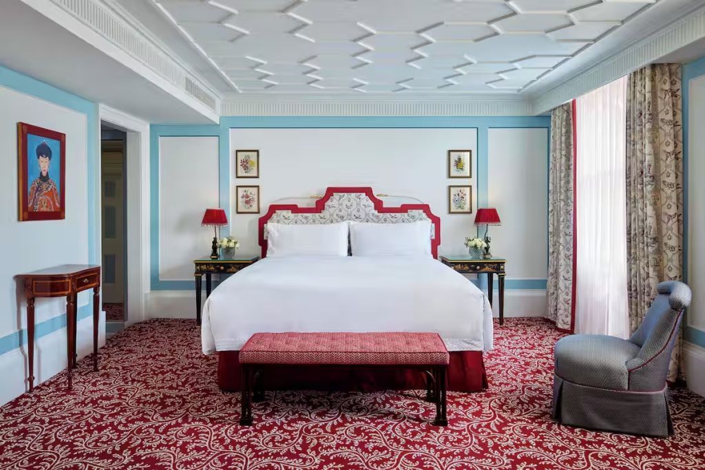 Luxuriöses Schlafzimmer mit großem Doppelbett und elegantem roten Teppich