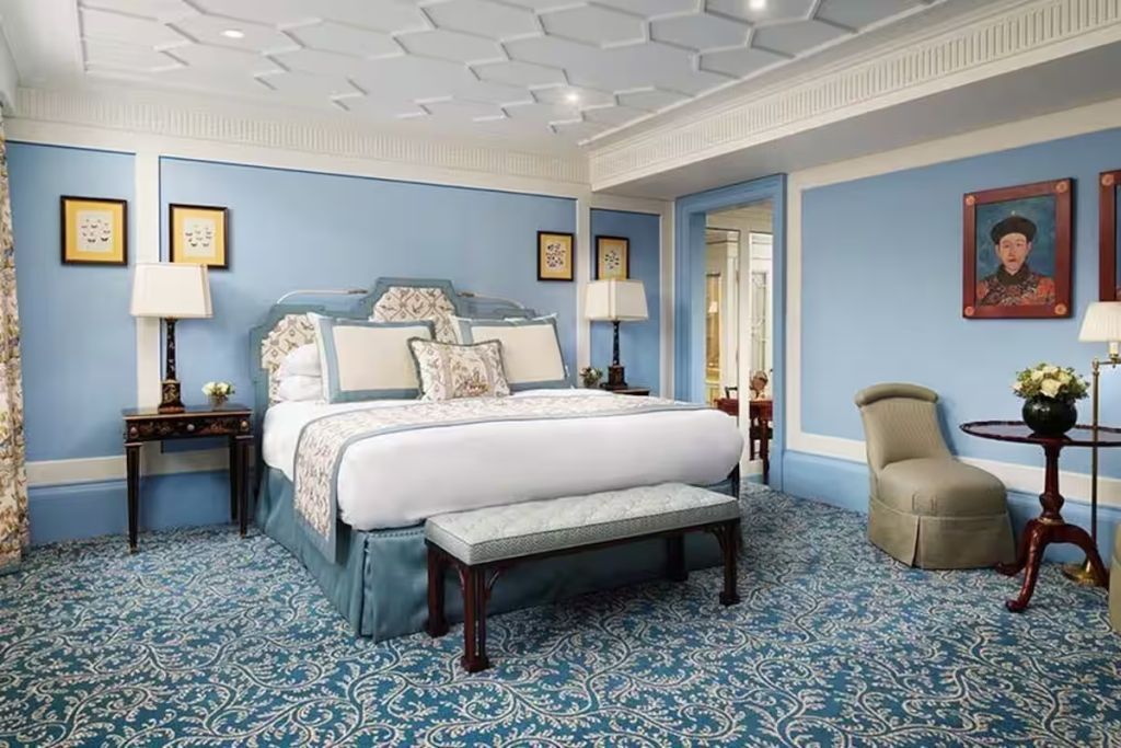 Großes Bett in einem hellblauen, geschmackvoll eingerichteten Zimmer