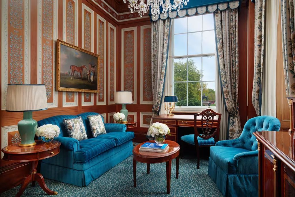 Elegantes Wohnzimmer mit blauen Möbeln und großem Fenster in der Suite.