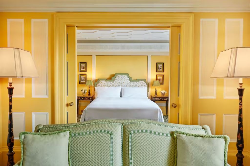 Gelbe Park Doppel Suite mit Bett und eleganten Details in klassischem Design.