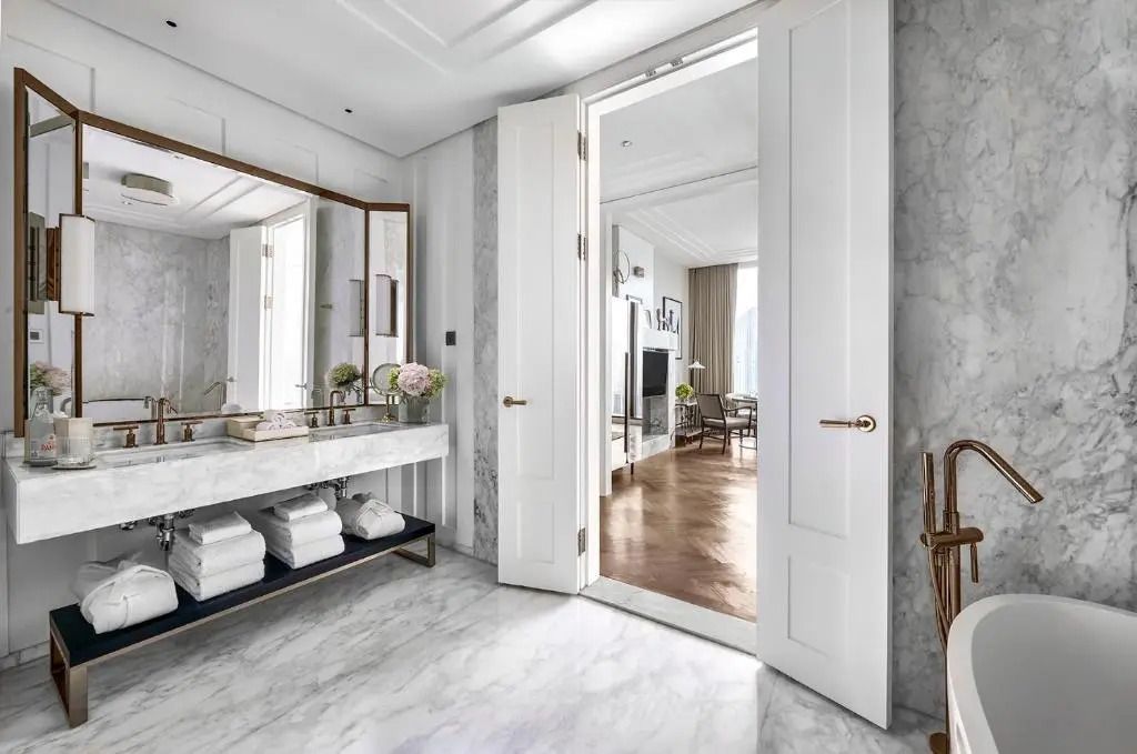 Badezimmer mit Marmor-Dekor und Blick in den Wohnbereich im Langham Jakarta